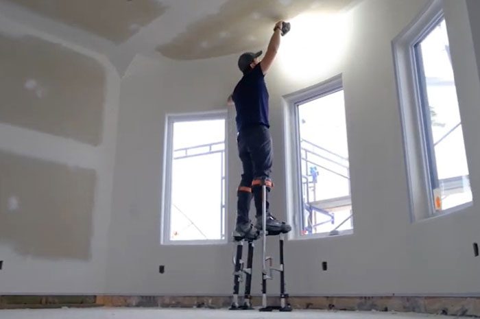 Beginner practicing walking on drywall stilts