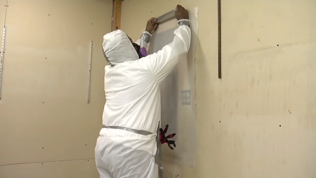 What are the common symptoms or health effects of asbestos exposure from drywall